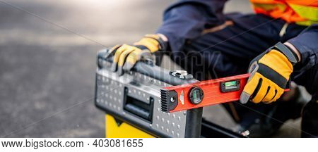 Male Mechanic Or Maintenance Worker Man Holding Red Aluminium Spirit Level Tool Or Bubble Levels And
