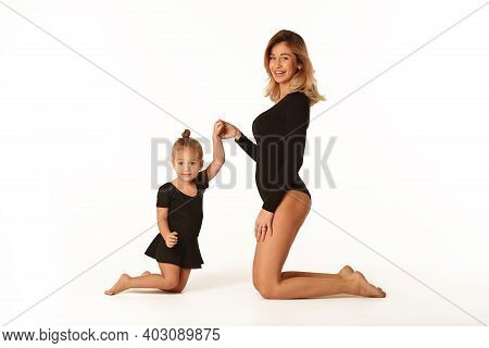 Cute Baby Girl And Mum In Black Bodies Having Fun Full Body Studio Portrait