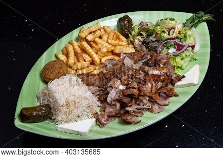 Libanese Combined Dish Meat, French Fries, Rice, Falafel And Vegetables.