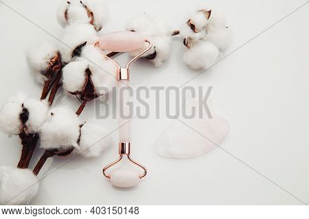 Pink Gua Sha Massage Tool On A Table With Cotton. Rose Quartz Roller. Facial Skin Care At Home, Anti