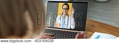 Female Doctor On Laptop Screen Waving Hand To Sick Patient. Development Of Telemedicine Online Consu