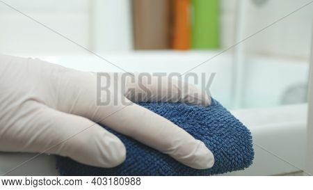 Nurse's Hand Cleaning The Bathtub Surface With A Dry Towel