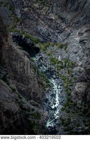 Dark Waters Of The Gunnison River Rush White In The Canyon Below The Rim