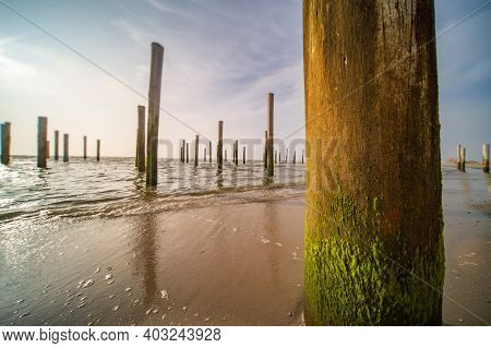 Long Exposure Seascape. Taken At The North Sea In Petten With The Pole Village In The Sea, Blue Sky,