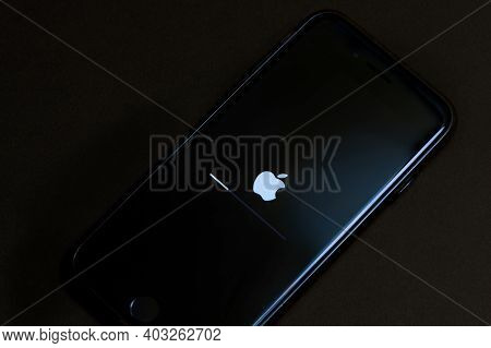 Moscow, Russia 13.01.2021: Old Black Iphone Smartphone Is Being Updated Its Firmware. Dark View.