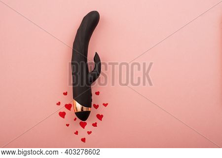 Black Clitoral Vaginal Dildo And Hearts On A Pink Background. Female Vibrator As A Gift For Valentin
