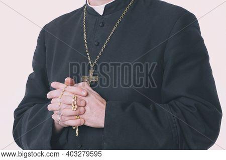 Catholic priest's hands holding the rosary