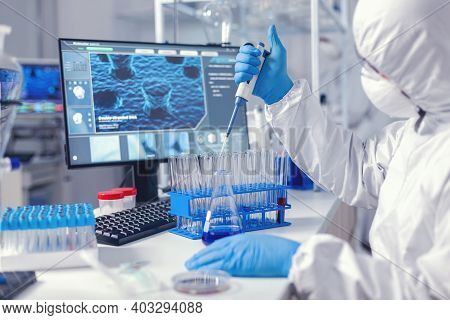 Healthcare Researcher In Ppe Suit Working With Micro Pipette In Time Of Coronavirus. Chemist In Mode