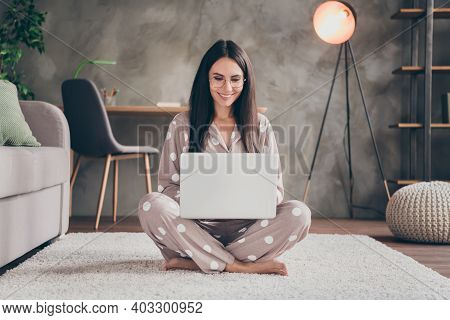 Photo Of Nice Sweet Girl Sit On Carpet Type Laptop Wear Spectacles Pijama At Home