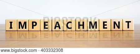 Impeachment Symbol. Wooden Cubes With The Word 'impeachment'. Beautiful Wooden Table, White Backgrou