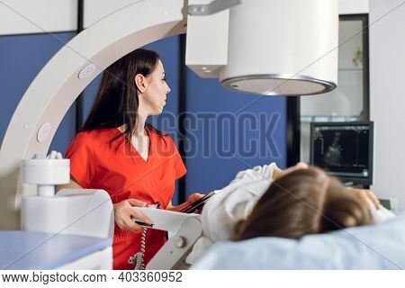 Extracorporeal Shock Wave Therapy. Kidney Stone Treatment. Side View Of Woman Doctor Looking At The 