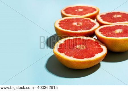 Five Grapefruits Cut In Half In Sunlight On Blue Neo Green Mint Background. Summer Natural Wallpaper