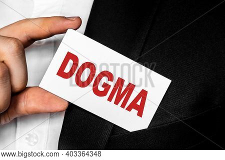 A Man In A Black Business Suit Lowers Or Removes From His Breast Pocket A White Business Card With T