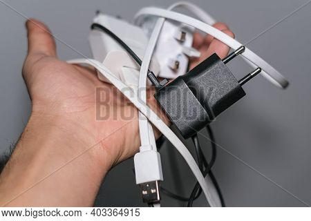 Man Hand Holding Bunch Of Smartphone Wired Chargers, Tech Power Devices Tools