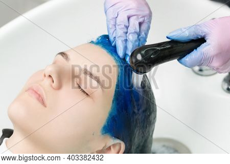 Hairdresser Washes Clients Head With Sapphire Hair Color After Hair Coloring Process. Washing Hair W