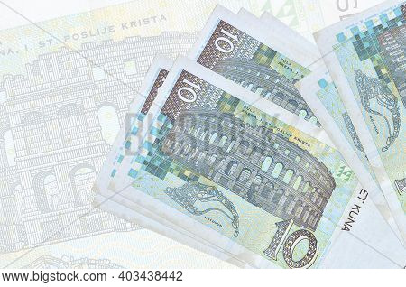 10 Croatian Kuna Bills Lies In Stack On Background Of Big Semi-transparent Banknote. Abstract Presen