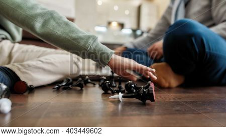 Game Over. Chess Figures On The Floor, Selective Focus, Little Boy Playing Chess With Grandfather At