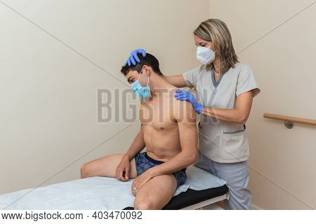 Woman Physiotherapist Does Massage To Man. Cervical Stretching, Upper Trapezium