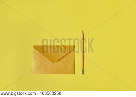 Flat Lay Composition Of A Yellow Enveloppe Near A Yellow Wooden Pencil Isolated On A Yellow Backgoun