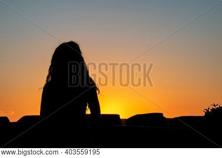 Silhouette Of A Woman Practising Yoga In The Evening.woman Thinking And Observing The Sunset. Horizo