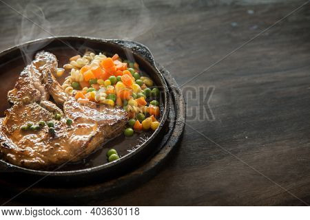 Pork Stake Serve On Hot Pan With Gravy Suace With Green Bean Carrot And Corn From Top View On Wood T