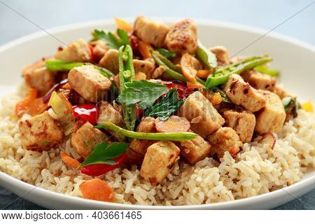 Vegetarian Meat Free Mycoprotein Pieces Vegetable Stir Fry, Brown Rice Served In White Plate