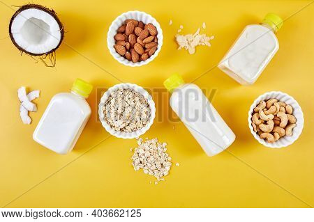 Alternative Types Of Vegan Milks In Bottles On A Yellow Background