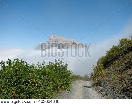 Russia, North Ossetia. The road to the Fiagdon relay. Mountain road among the greenery. Clouds below