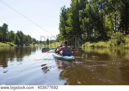 A Couple Of Men And Women Kayak On The River In The Summer. Active Recreation, Family Travel, Extrem