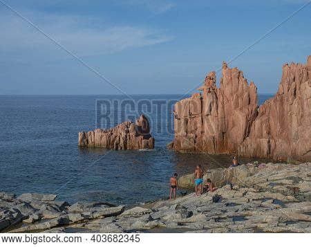 Arbatax, Sardinia, Italy, September 9, 2020: Two Young Men Jumping From Red Rocks, Rocce Rosse At Me