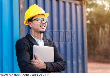 Asian Yong Business Man Import And Export Goods Wear A Helmet Logitics Shipping At Container Backgro