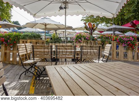 Idyllic Beer Garden Scenery With Seats, Tables And Sunshade