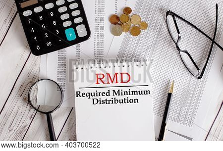 Rmd Written In A White Notepad Near A Calculator, Cash, Glasses, A Magnifying Glass And A Pen. Busin