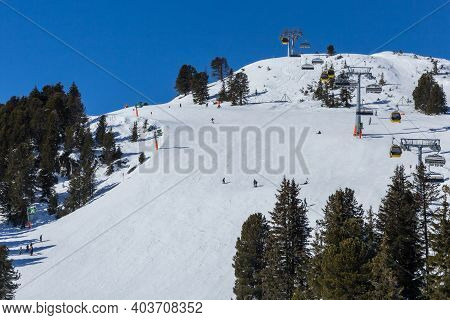 Skiiers And Snowboarders Enjoying A Snow Covered Mountain