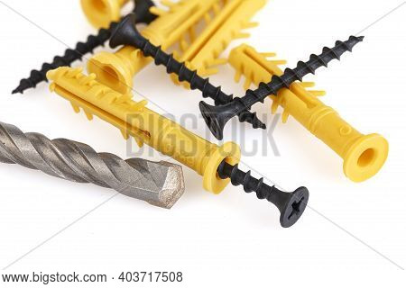 Drill, Dowels And Screws Isolated On White Background. Yellow Plastic Dowel - Fasteners And Concrete