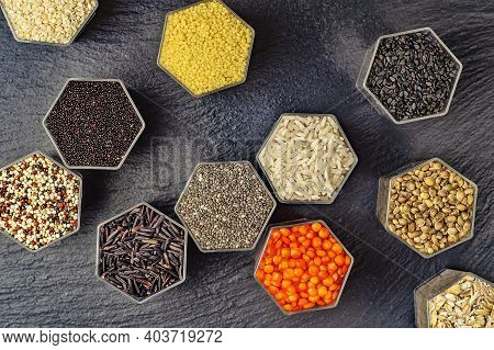 Food Background Of Various Cereals And Grains In Hexagonal Shaped Honeycomb Jars