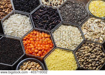 Food Background Of Various Cereals And Grains In The Hexagonal Honeycomb Jars