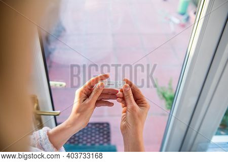 Close Up Woman Holding Rapid Covid -19 Test With A Positive Result. Self Express Coronavirus Testing