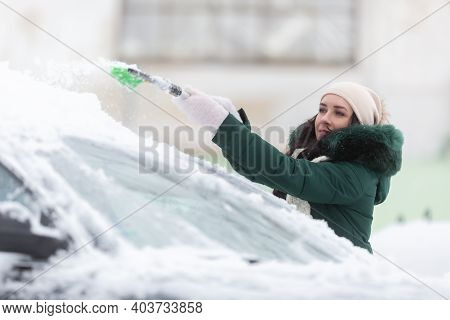 Woman Is Too Short To Clean Snow From The Tope Of Her Car After Heave Snowfall Left Vehicles Covered