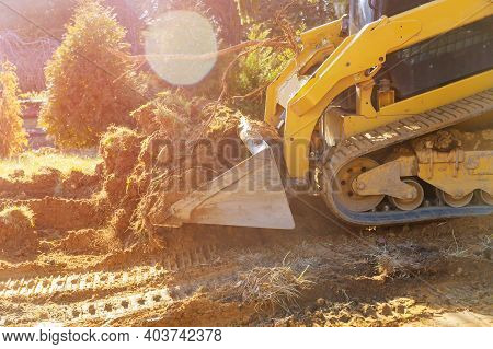 Mini Bulldozer Working With Earth While Doing Landscaping Works On Construction Moving Soil