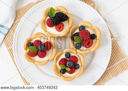 Delicious Pastry Mini Fruit Cream Cheese Pies Or Tart Cakes With Fresh Raspberry, Blueberry And Blac