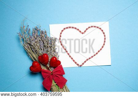 Valentines Day Congratulation. Red Rose And Greeting Card With Heart Sign On Blue Background Top Vie