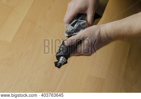 Continuous Light Photographic Equipment, Softbox. A Hand Pulls A New Black Softbox Tripod In Clear P