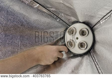 Man's Hand Screws Special Electric Lights Into The Softbox Holder. Studio Lighting Assembly Sequence