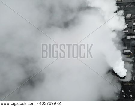 Top Down View Over A Large Factory With Smoke And Steam Coming From Its Chimneys.