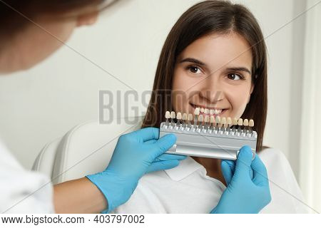 Doctor Checking Young Woman's Teeth Color In Clinic. Cosmetic Dentistry