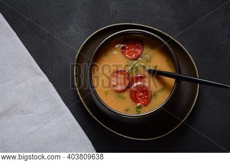 Caldo Verde Soup With Greens And Chopped Chorizo On The Top In The Bowl On A Dark Background.