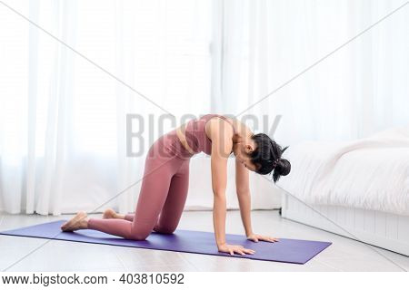 Young Woman Do Yoga In A Bed Room