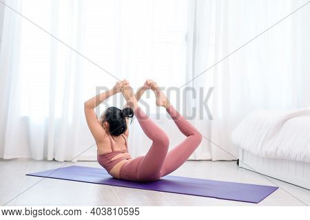 Young Woman Do Yoga In A Bed Room