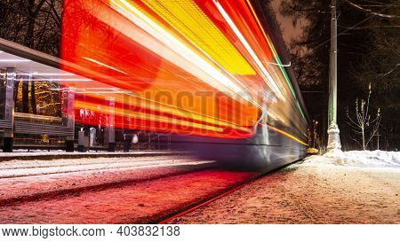Public Transportation In A City. Tram Leaving The Station, Traffic Lights, People, Street, Houses, O